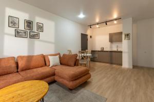 a living room with a couch and a kitchen at Sella Mestia in Mestia