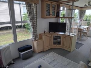 a living room with a flat screen tv on a cabinet at 11 Oaklands in Porchfield