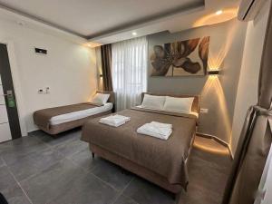 a hotel room with two beds and a window at Babil Hotel in Antalya