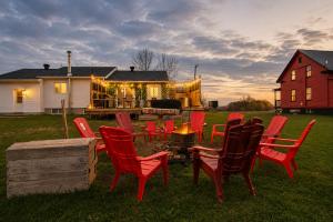 a group of red chairs and a fire pit in a yard at Domaine pour 27 pers avec SPA et GRANGE Festive in Saint-Justin