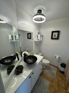 a bathroom with two sinks and a toilet at Whales house in Horseshoe Bay