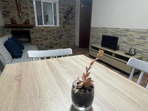 a wooden table with a vase with a plant on it at La casa del rio cauche in Almogía