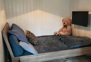 a teddy bear sitting on top of a bed at Small Cozy apartment with Wi-Fi in Tjørhom