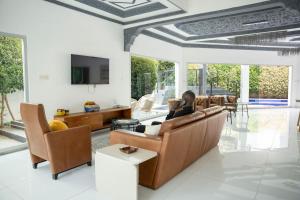 a woman sitting on a couch in a living room at Francesca Guest House in Dakar