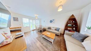 a living room with a couch and a table at Life of Filey - Part of the The Bay Filey Holiday Village with pool, gym and direct beach access, pub, restaurant, tennis and meadows walks in Reighton