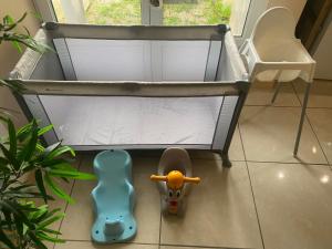 a baby crib with a pair of shoes and a toy at Calme et nature in Venoy +4 photos