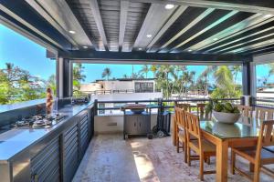 a kitchen with a table and chairs and a large window at apartement rooftop oceanfront - Hotel Aligio in Las Terrenas