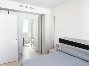 a white bedroom with a bed and a window at Conero View in Marcelli