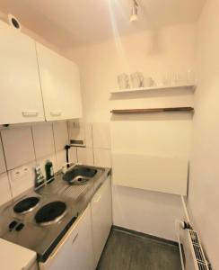 a small white kitchen with a sink and a counter at Tolle Stadtwohnung in Darmstadt