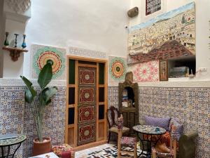 a room with tiles on the wall with a table and chairs at Riad La Mentha Panoramic Terrace in Fes Medina in Fez