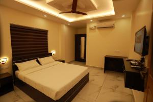 a bedroom with a bed and a ceiling fan at Aman Residency in Thodupuzha