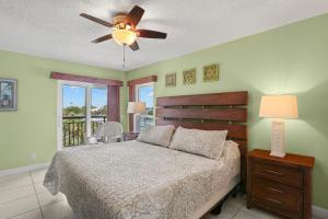 a bedroom with a bed and a ceiling fan at Gulf Strand Resort by Travel Resort Services in St. Pete Beach +224 photos