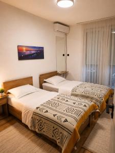 two beds in a hotel room at Nesi apartmenti in Prishtinë +4 photos