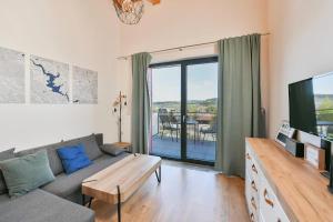 a living room with a couch and a tv at Relax in Korzo Lipno in Lipno nad Vltavou