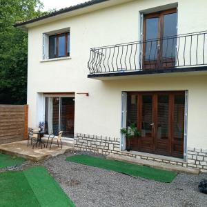 a white house with a balcony and a table at Pearly Maison Central Ruffec in Ruffec