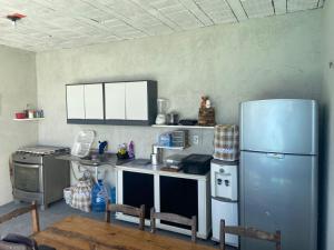 a kitchen with a refrigerator and a table and chairs at Casa do Arruda na tabuba in Caucaia