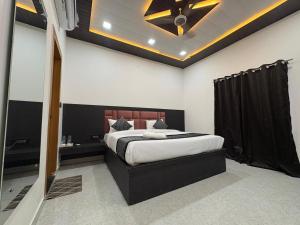 a bedroom with a bed and a ceiling fan at Hotel Pearl Nest Palace in Agra +23 photos