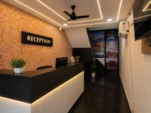 a reception desk in an office with a ceiling fan at Hotel Pearl Nest Palace in Agra