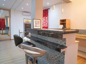 a bar with two stools in a room at Agréable suite situé dans une villa in Rabat