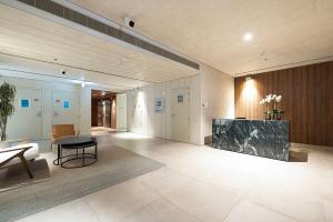 a lobby of a building with a table and a couch at Luxury Studio With Private Garden - Uptown Al Zahia Sharjah in Ḩiz̧āyib az Zānah +34 photos