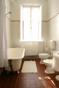 baño con bañera y aseo y ventana en B&B Le Tortore, en Melara