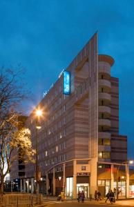 a hotel building with a blue sign on it at ibis budget Paris Porte De Montmartre in Paris