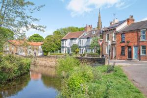 a town with a river in front of buildings at 1 Bed in Middlesbrough oc-79273 in Great Ayton