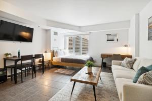 a living room with a couch and a bed and a table at Great Located Studio perfect for 2 with parking in Toronto