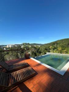 a deck with a swimming pool on top of a house at Artha Home Spa in Governador Celso Ramos