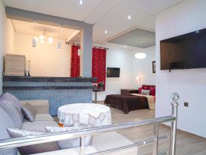 a living room with a couch a table and a tv at Agréable suite situé dans une villa in Rabat