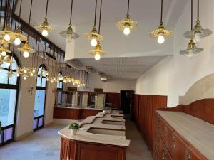 a row of tables in a restaurant with lights at Smart Wellness Hotel TREZOR in Pécs