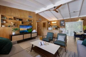 a living room with a couch and a tv at Bos Beach Bungalow in Anna Maria
