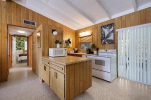 a kitchen with wooden walls and white appliances at Bos Beach Bungalow in Anna Maria +24 photos