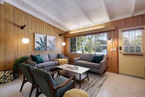 a living room with two couches and a table at Bos Beach Bungalow in Anna Maria