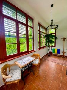 a dining room with a table and chairs and windows at Apartmán Dobrá Naděje in Uherské Hradiště
