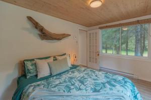 a bedroom with a bed and a window at Riverfront Getaway with Hot Tub and Scenic Views in Mont-Tremblant