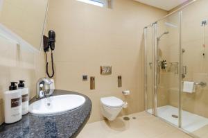 a bathroom with a sink and a shower and a toilet at TURIM Aveiro Palace Hotel in Aveiro +84 photos