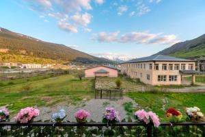 a view of a building with flowers on a fence at Sella Mestia in Mestia