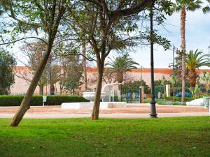 a park with a fountain and trees in a park at Agréable suite situé dans une villa in Rabat