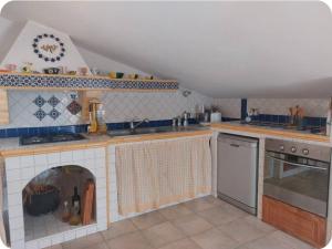 a kitchen with a fireplace in the middle of it at Casa Wendy in Carloforte