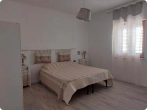 a bedroom with a large bed in a white room at Casa Wendy in Carloforte