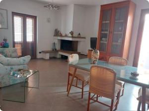 a living room with a glass table and chairs at Casa Wendy in Carloforte