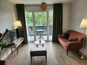 a living room with a couch and a chair at DOMITYS - Les Arilles in Ifs +3 photos