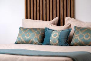 a bed with blue and brown pillows on it at Marvel Suite in Imerovigli +34 photos