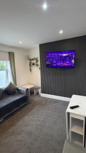 a living room with a couch and a tv on a wall at Beach & city Homestay in Waterloo