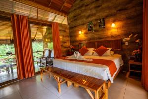 a bedroom with a bed and a wooden wall at Suchipakari Amazon Eco -Lodge & Jungle Reserve in Puerto Misahuallí +133 photos