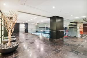 a lobby with a potted tree and glass walls at Great Located Studio perfect for 2 with parking in Toronto +22 photos