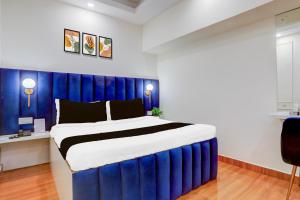 a bedroom with a large bed with a blue headboard at Hotel O Kings Hotel & Banquet in Siliguri