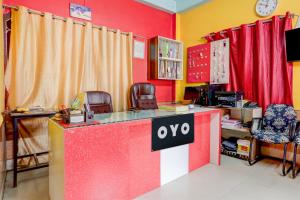an office with a red and yellow wall and a desk at Hotel O Kings Hotel & Banquet in Siliguri
