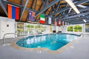 a large swimming pool with flags in a building at Pier 7 Condominium Resort in Yarmouth